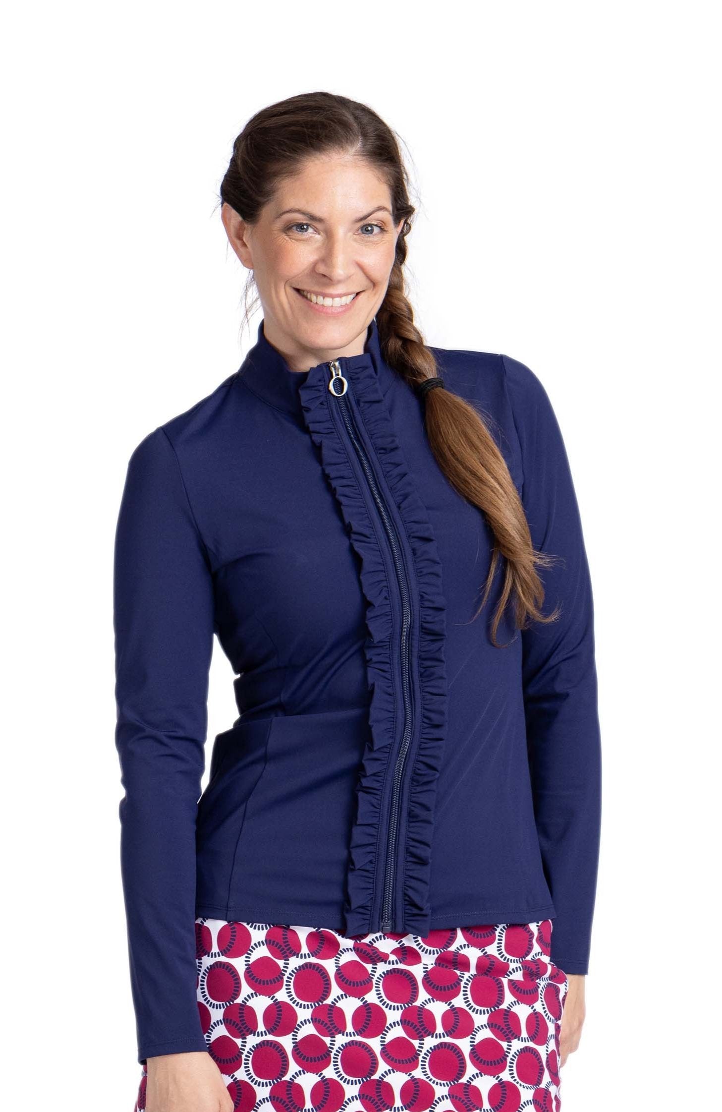 Woman wearing a navy blue long sleeve top with zipper front closure and ruffle detail down each side of the zipper.