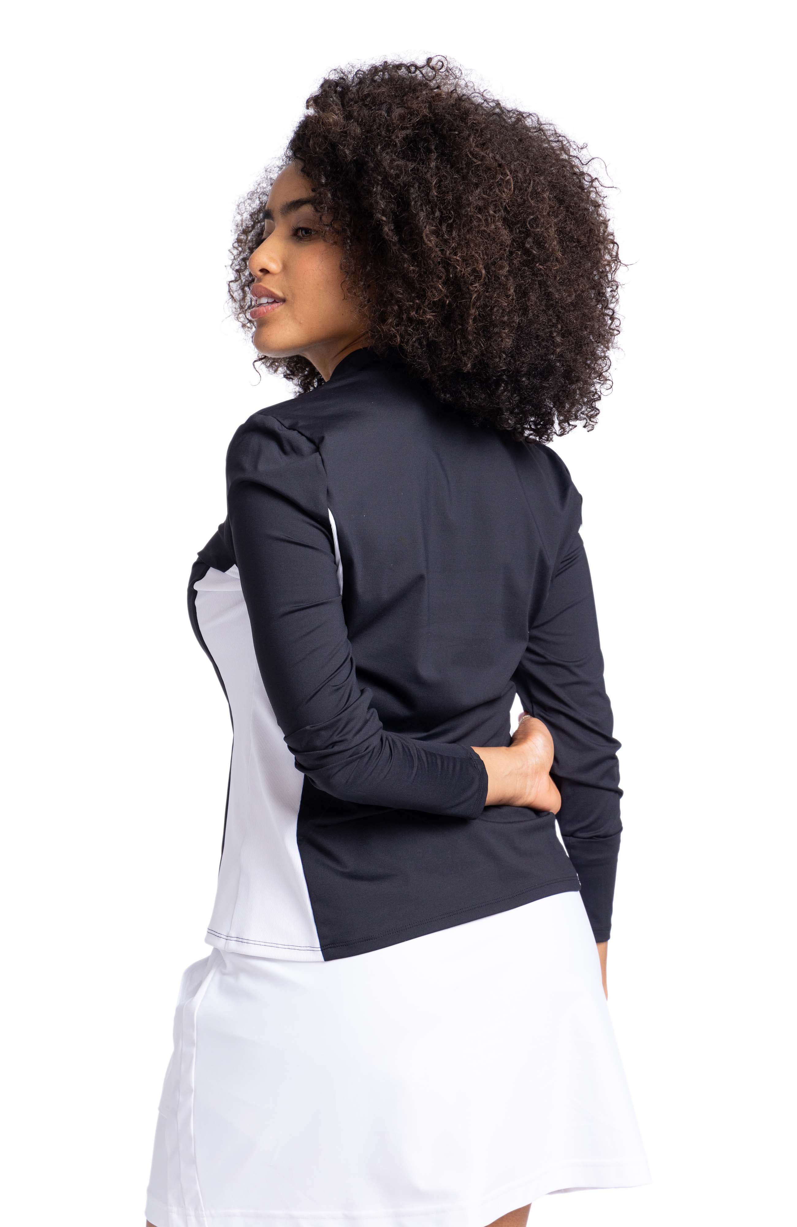 Back view of a woman wearing a black longsleeve top with white contrasting side panel.